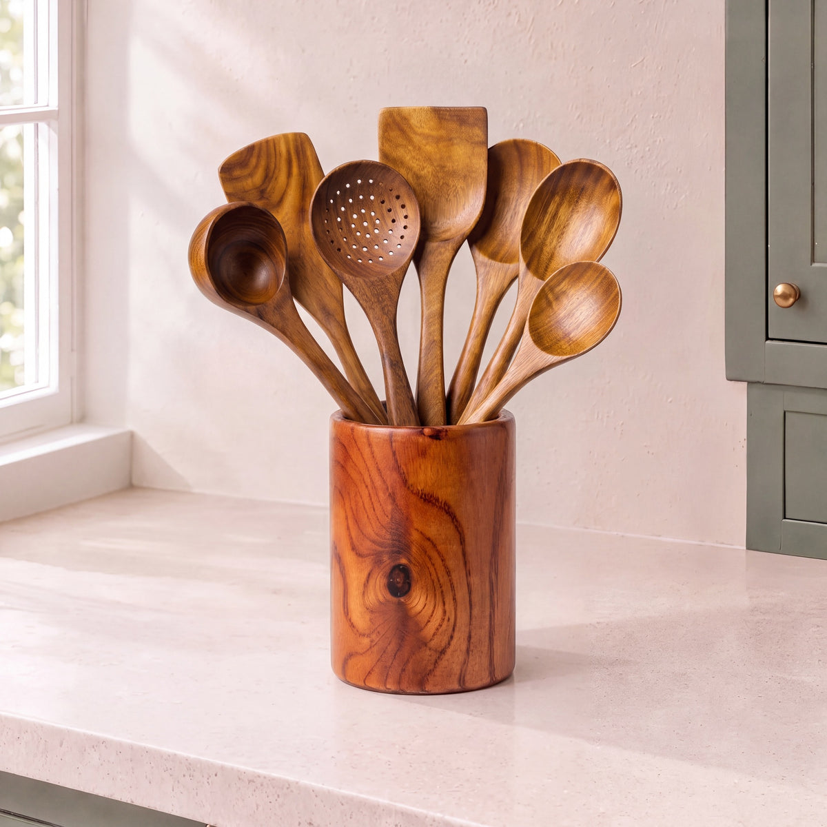 7-piece teak utensil set in its holder on a stone kitchen counter