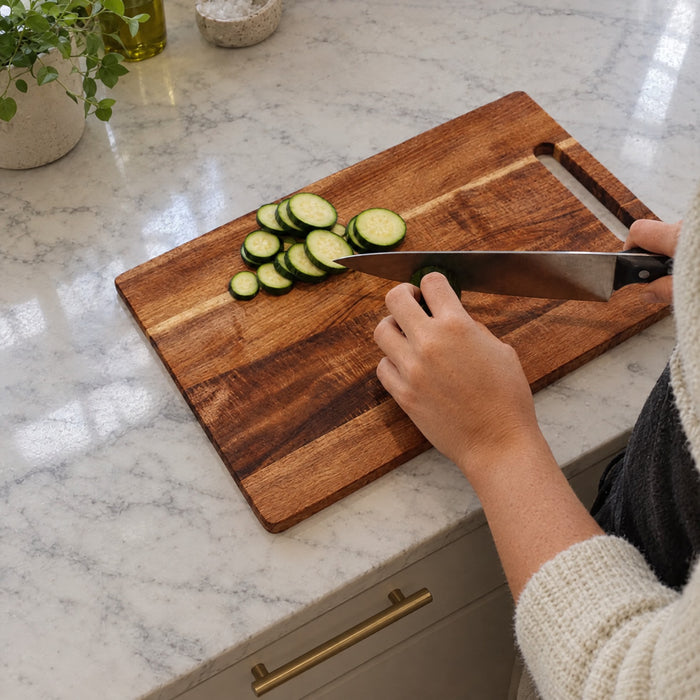 Slicing cucumber on an acacia cutting board