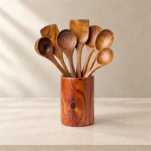 Small leaf acacia utensils in holder on a limestone counter